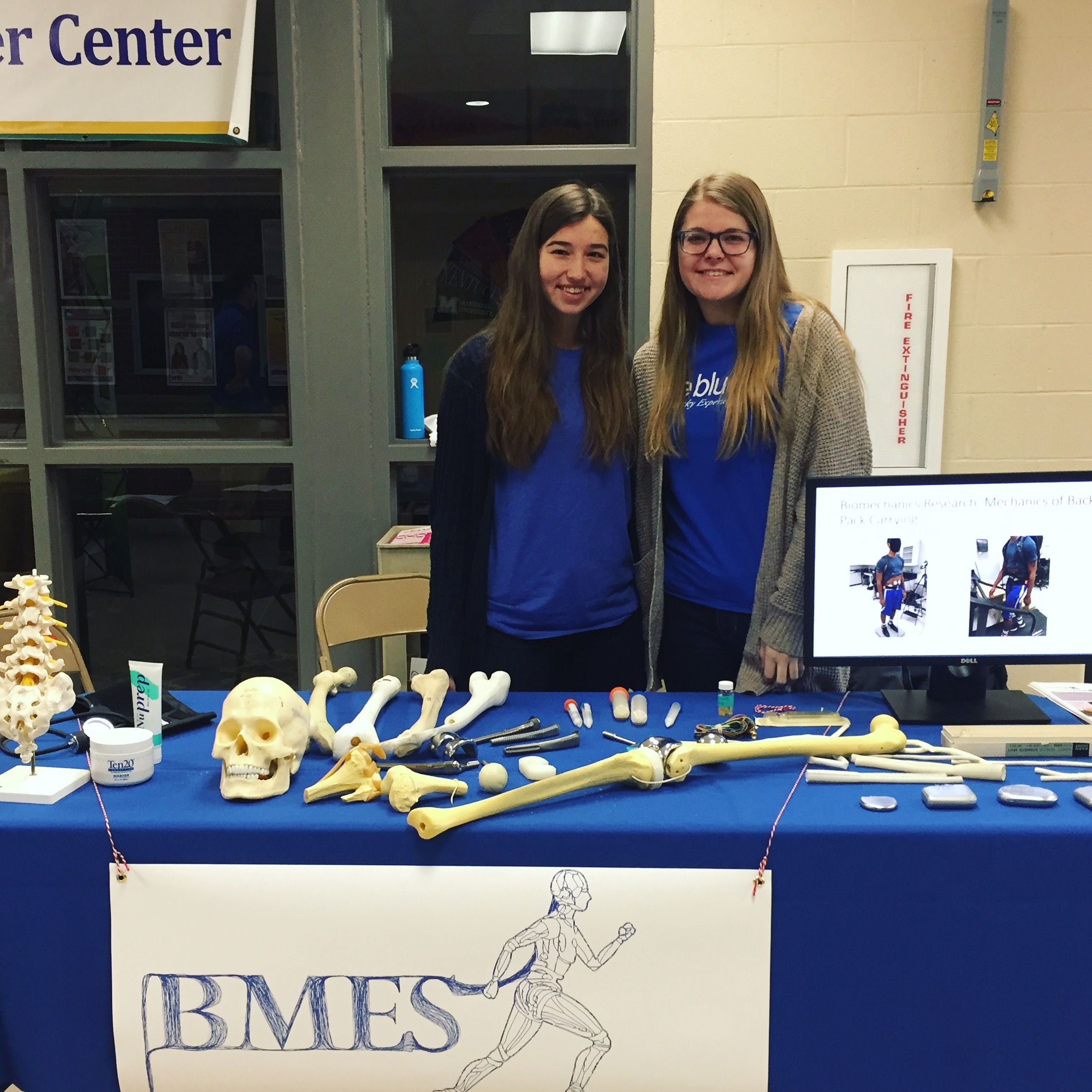 Undergraduate UK BMES members, Brittney Williams (left) and Madison Peppenhorst (right), behind the UK BMES science fair exhibit.